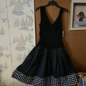 Black sleeveless dress with decorative black and white plaid at bottom zipper